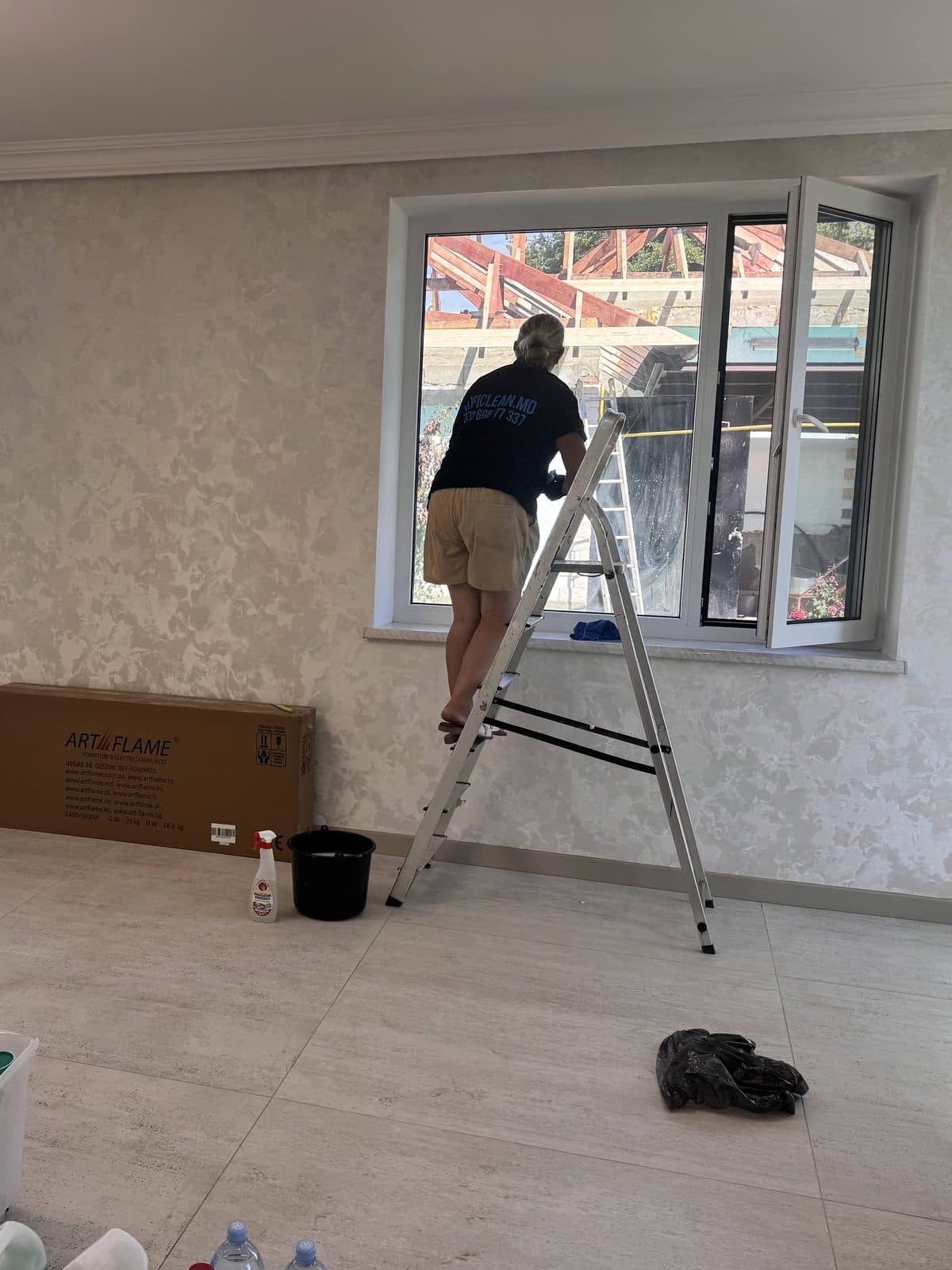Coleg ProfiClean spală geamurile unei locuințe noi, de pe scară