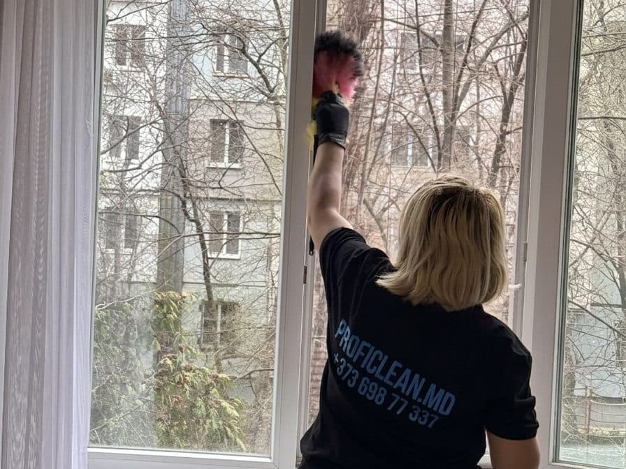 Сотрудница ProfiClean моет окна у клиента дома